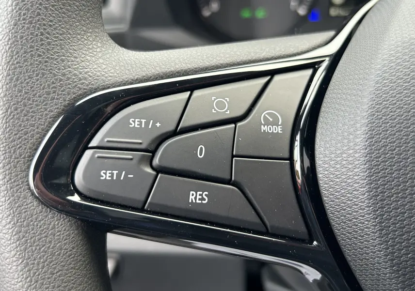 Gros plan sur les commandes noires du volant du Renault Master 2026, boutons de régulateur de vitesse et mode.