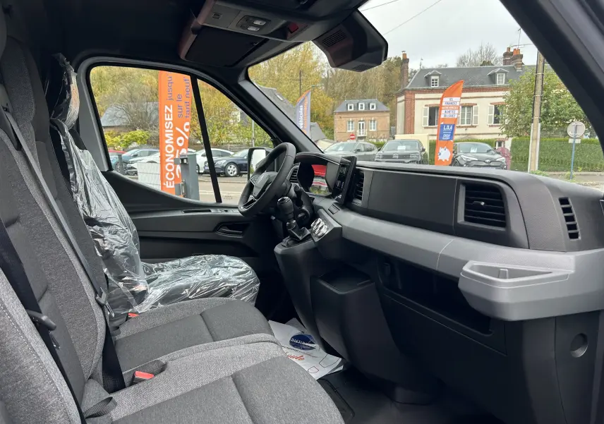 Vue intérieure côté passager avant du Renault Master blanc, montrant la banquette 2 places et le tableau de bord moderne.