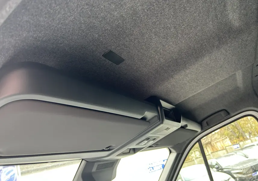 Vue intérieure du plafond et pare-soleil côté conducteur du Renault Master blanc, avec fenêtre latérale visible.