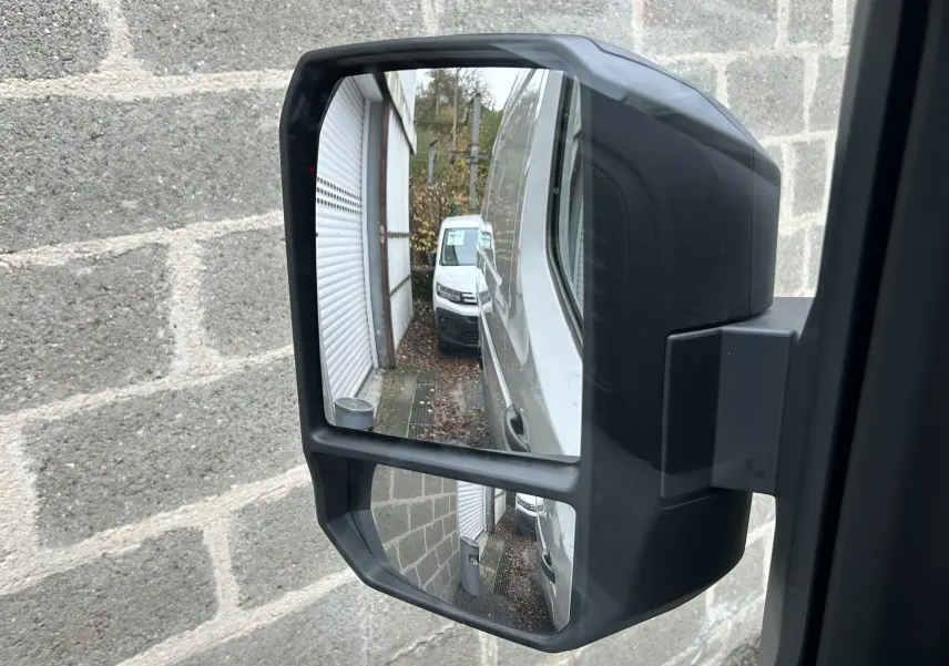 Rétroviseur droit du Renault Master blanc montrant la carrosserie et un autre fourgon blanc en arrière-plan.
