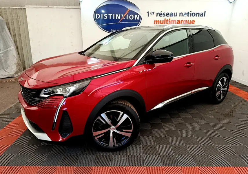 Peugeot 3008 GT rouge vue 3/4 avant droit en intérieur, avec jantes alliage et toit noir contrasté.