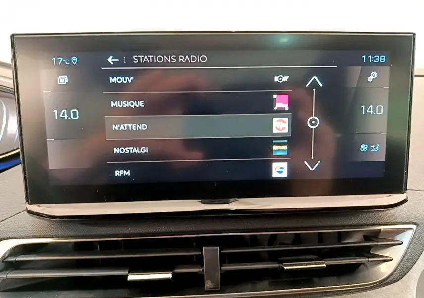 Écran tactile central affichant les stations radio dans l'habitacle du Peugeot 3008 rouge, vue de face.
