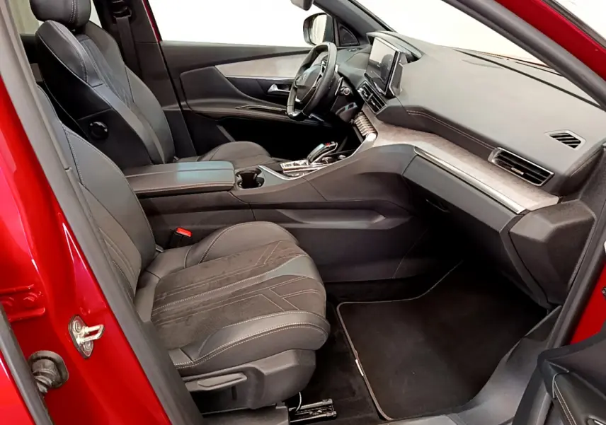 Intérieur côté conducteur du Peugeot 3008 GT rouge 2021, avec sièges cuir et tableau de bord moderne tactile.