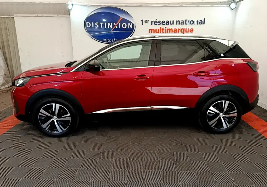 Profil côté gauche du Peugeot 3008 GT rouge de 2021 avec toit noir et jantes alliage bicolores.