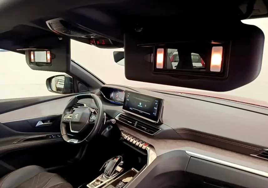 Intérieur du Peugeot 3008 GT 2021 vu côté conducteur, volant cuir et écran tactile central allumé.