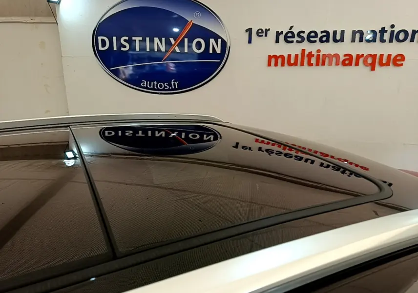 Toit ouvrant panoramique en verre du Peugeot 3008 GT rouge, vue rapprochée sur le toit et les barres de toit chromées.