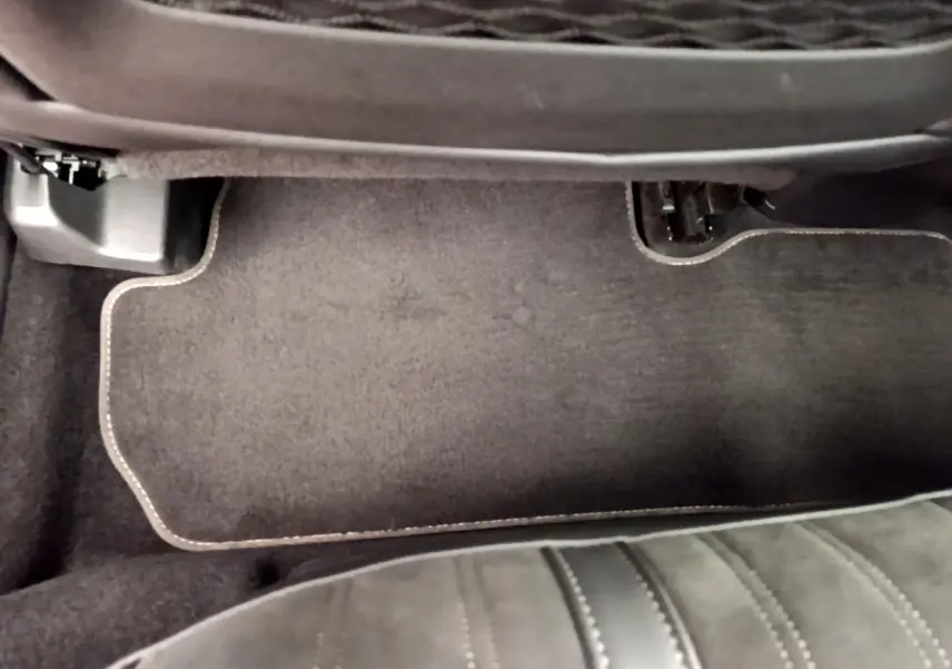 Détail du tapis de sol noir et couture beige côté passager avant du Peugeot 3008 GT rouge 2021.