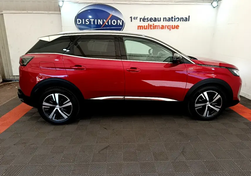 Profil côté gauche du Peugeot 3008 GT rouge 2021 avec toit blanc et jantes alliage noires et argentées.