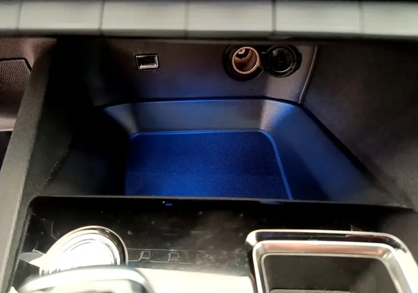 Gros plan sur la console centrale noire du Peugeot 3008 GT 2021 avec prise USB et allume-cigare visibles.