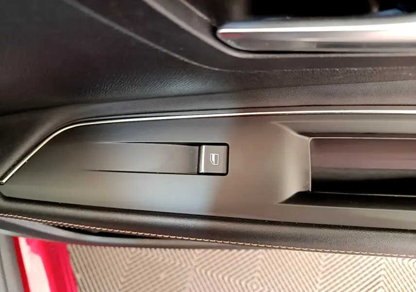 Détail de la commande de lève-vitre sur la portière côté gauche d’un Peugeot 3008 GT rouge 2021.