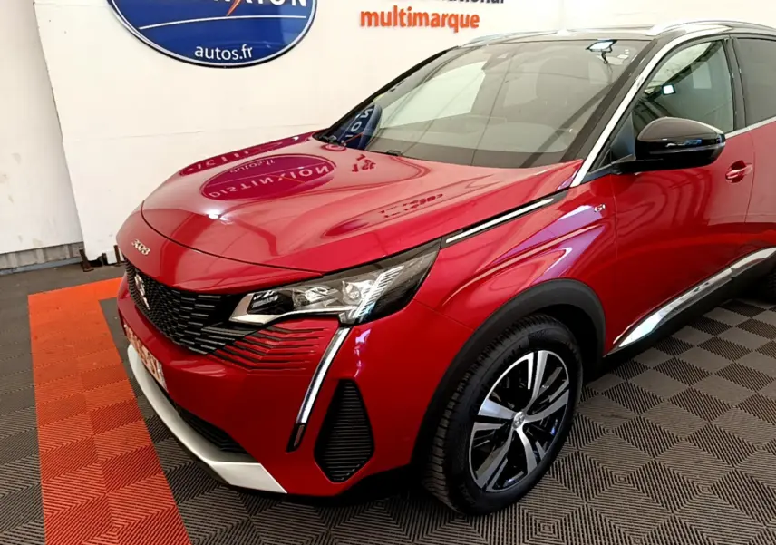 Peugeot 3008 rouge vue 3/4 avant droit, avec phares LED et jantes alliage distinctives dans un showroom.