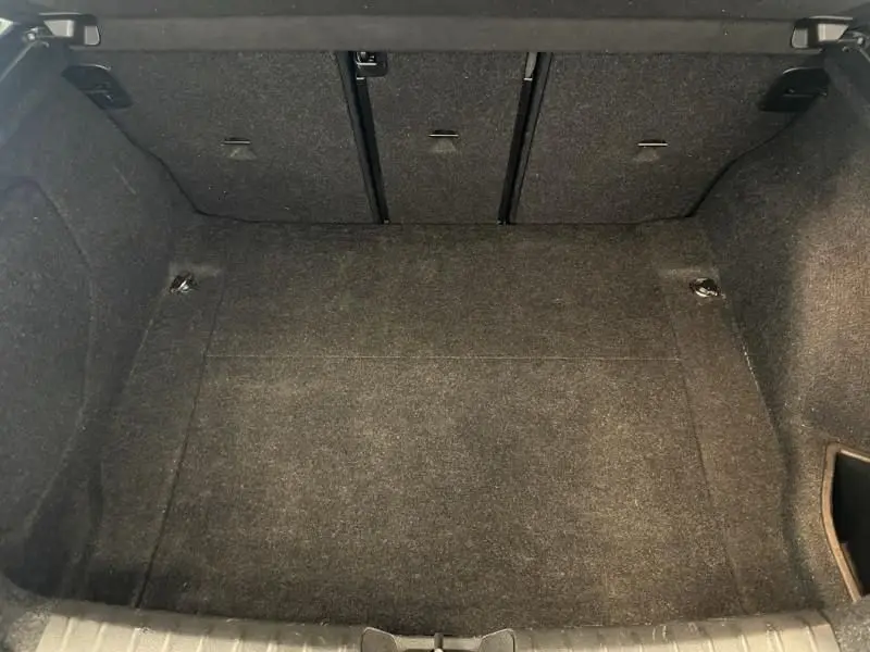 Coffre vide vu de face d'une BMW Série 1 135i 320CV M 2013 bleu métal, revêtement intérieur gris foncé.