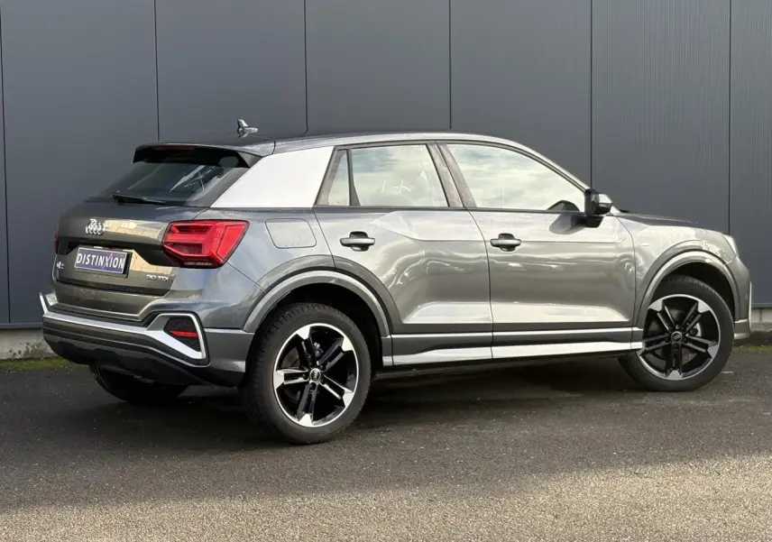 Audi Q2 30 TDI S-Line gris Daytona vue 3/4 arrière droit, avec toit contrasté blanc et jantes Audi Sport 5 branches.
