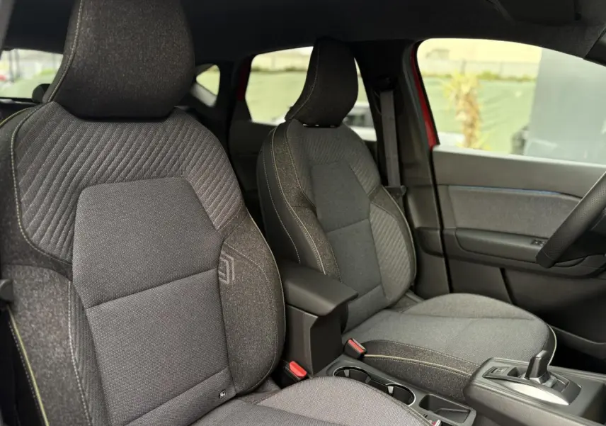 Vue intérieure des sièges avant gris foncé du Renault Captur 2026 avec console centrale et levier de vitesse automatique.