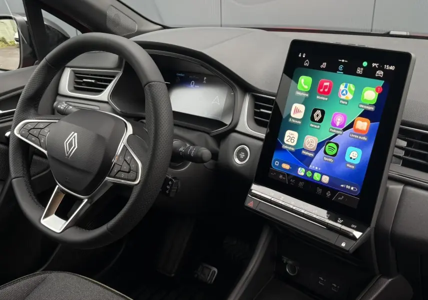 Vue intérieure du tableau de bord du Renault Captur 2026, avec écran tactile vertical et volant multifonction noir.