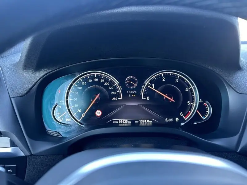 Vue rapprochée du tableau de bord numérique du BMW X4 X-Line 2019 gris foncé, affichant vitesse et compte-tours.