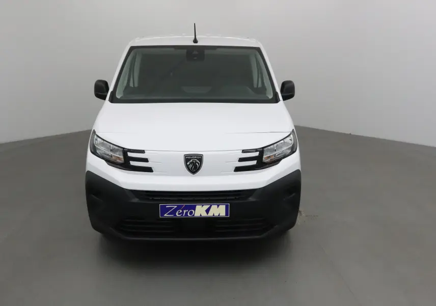Vue frontale d'un utilitaire Peugeot Partner blanc avec calandre noire et logo lion central, sur fond neutre gris.