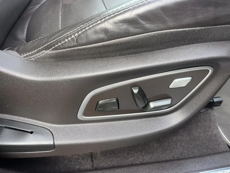 Détail des commandes de réglage électrique du siège conducteur en cuir noir du Renault Espace Gris Cassiopée 2018.