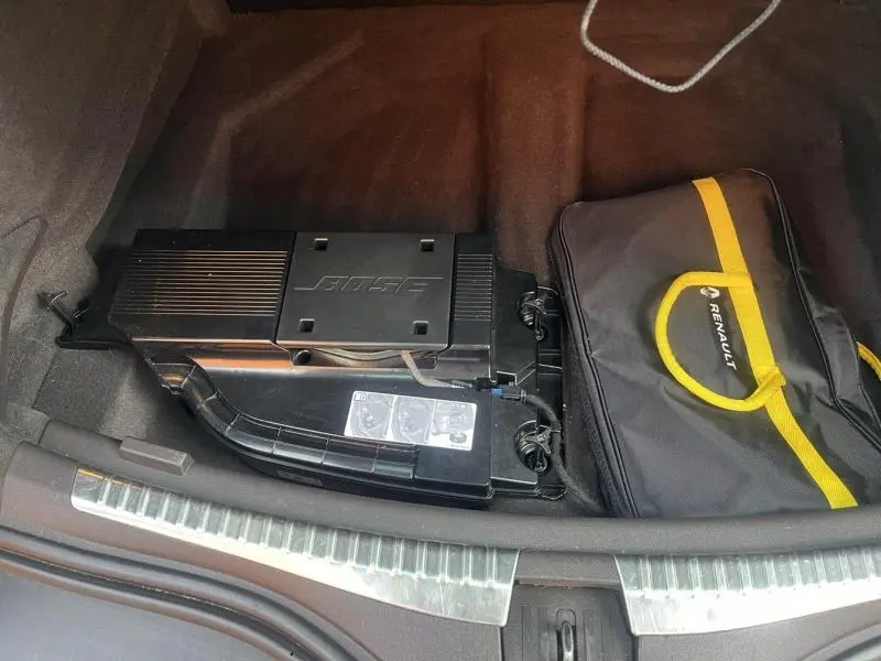 Vue du coffre du Renault Espace gris Cassiopée de 2018, montrant un caisson Bose et une trousse Renault noire et jaune.