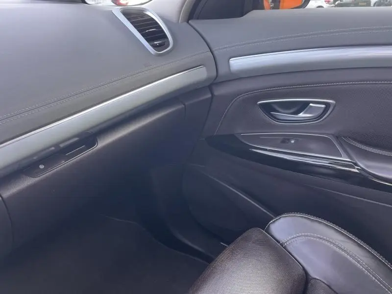 Vue intérieure côté passager du tableau de bord et de la porte en cuir noir avec inserts argentés du Renault Espace Gris Cassiopée 2018.