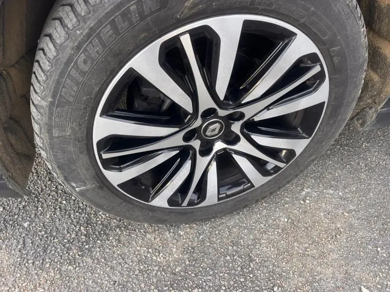 Gros plan sur la jante alliage bicolore noire et argentée d’un Renault Espace gris Cassiopée, roue avant droite.