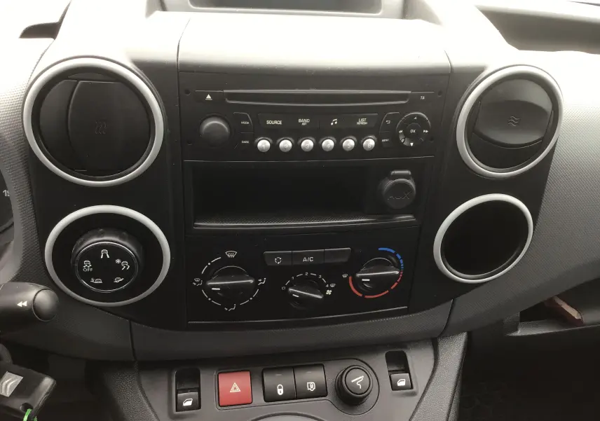 Vue rapprochée du tableau de bord noir du Citroën Berlingo 2019 avec commandes de climatisation et radio intégrée.