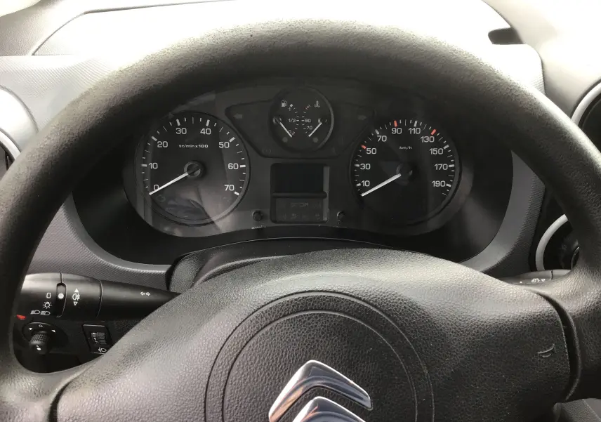 Vue rapprochée du tableau de bord et volant noir avec logo Citroën d'un Berlingo blanc diesel de 2019.