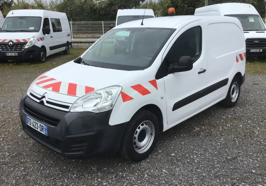 Vue 3/4 avant d'un Citroën Berlingo blanc 2019 avec bandes rouges réfléchissantes et gyrophare orange sur le toit.