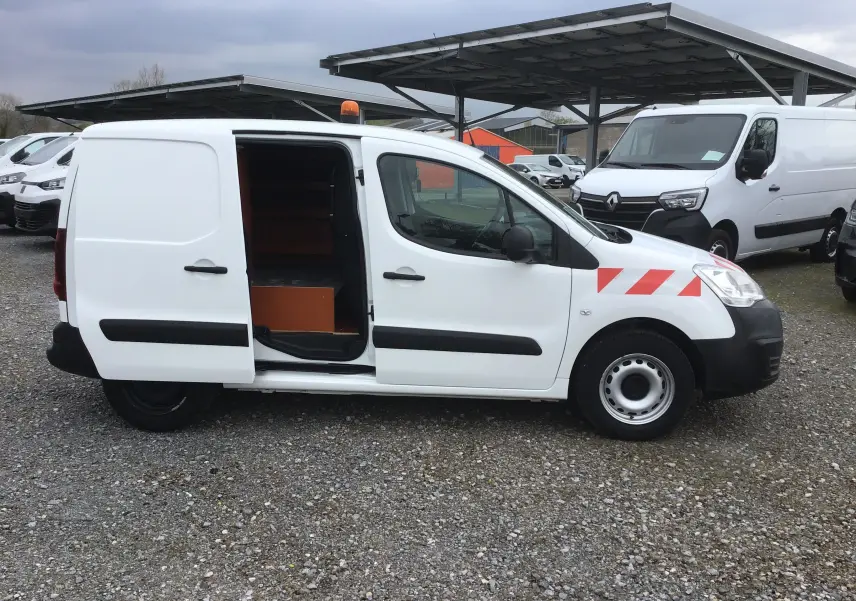 Vue latérale droite d’un Citroën Berlingo blanc 2019 avec porte coulissante ouverte et étagères en bois visibles à l’intérieur.