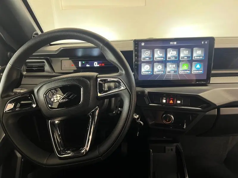 Vue intérieure du tableau de bord et volant noir de la Ligier JS50 Sport Elite E5+ 2025 avec écran tactile central lumineux.