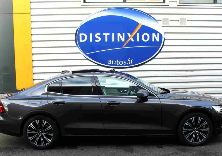 Profil côté gauche d'une Volvo S60 gris métal 2024 avec jantes alliage et toit ouvrant panoramique visible.