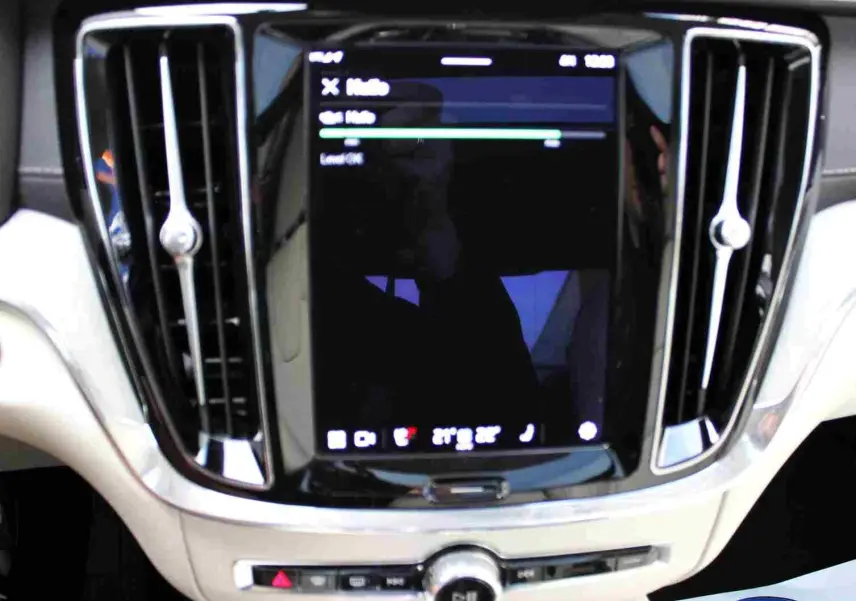 Écran tactile central avec commandes et aérateurs chromés dans l’habitacle clair du Volvo S60 T6 hybride 2024