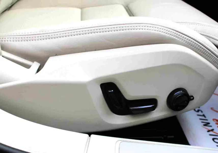 Réglage électrique du siège avant en cuir beige clair dans une Volvo S60 2024 hybride rechargeable