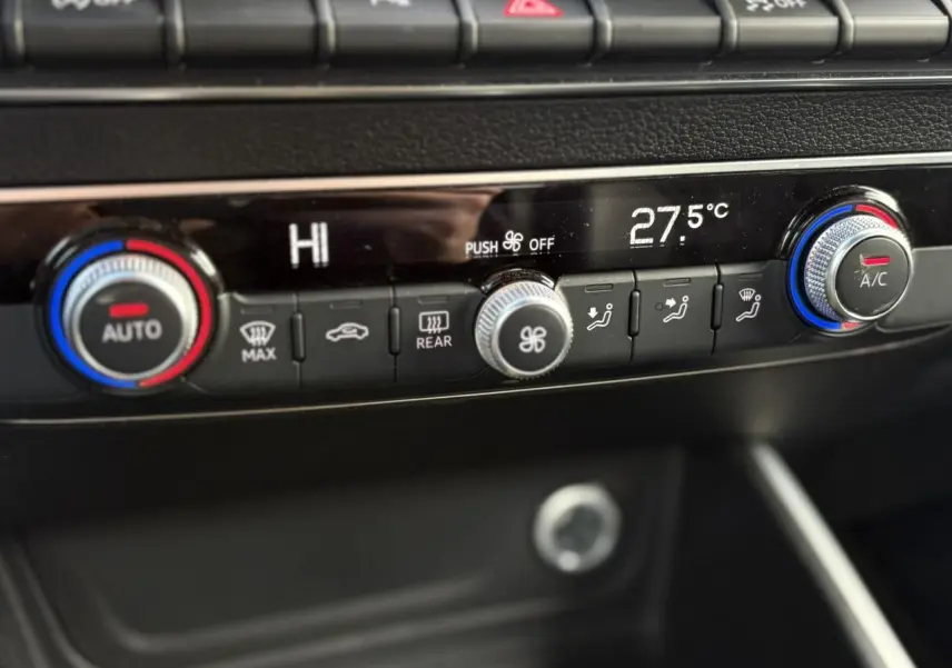 Gros plan sur la commande de climatisation automatique bicolore de l'Audi Q2 35 TDI S-Line 2025 argent rosé.