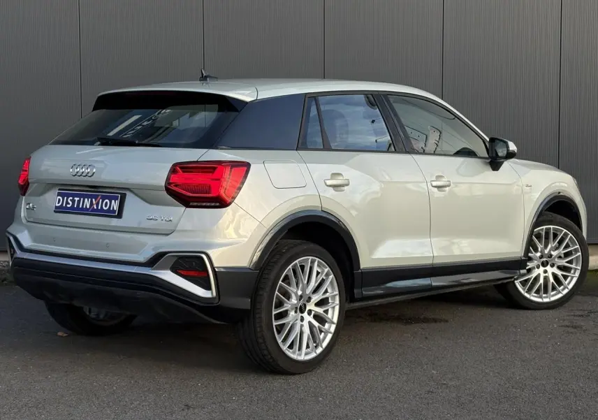 Audi Q2 35 TDI S-Line argent rosé en vue 3/4 arrière droit, avec feux arrière LED et jantes alliage distinctives.