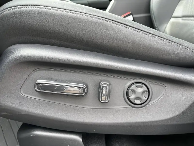 Détail des commandes électriques de réglage du siège en cuir noir à l'intérieur du Honda CR-V blanc nacré 2024.