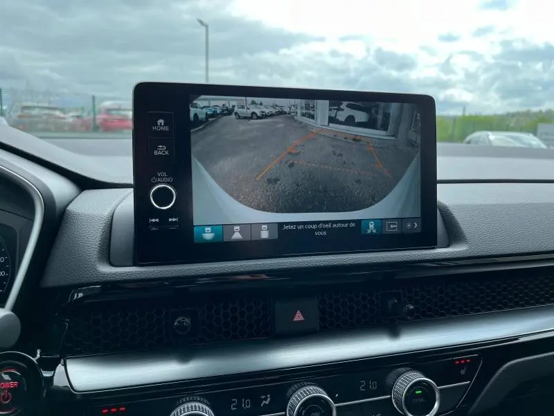 Écran tactile central montrant la caméra de recul d’un Honda CR-V blanc platine, vue intérieure avant.