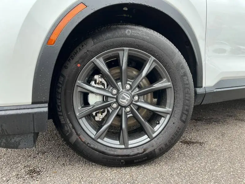 Gros plan sur la roue avant droite d’un Honda CR-V blanc nacré avec jante alliage 18 pouces et pneu Michelin.
