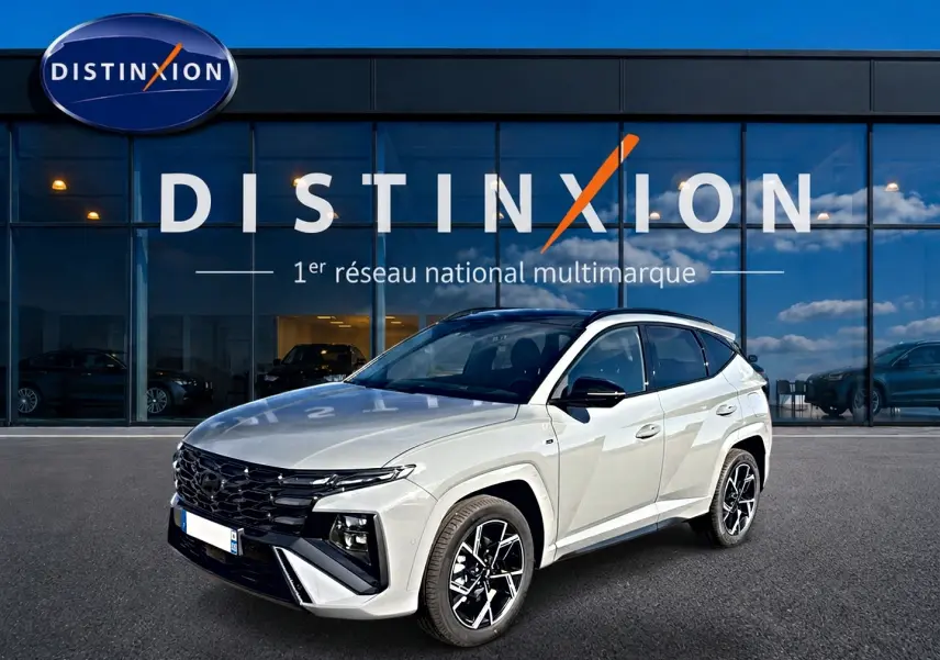 Hyundai Tucson 2026 gris shadow en 3/4 avant droit, avec calandre noire et jantes alu distinctives.