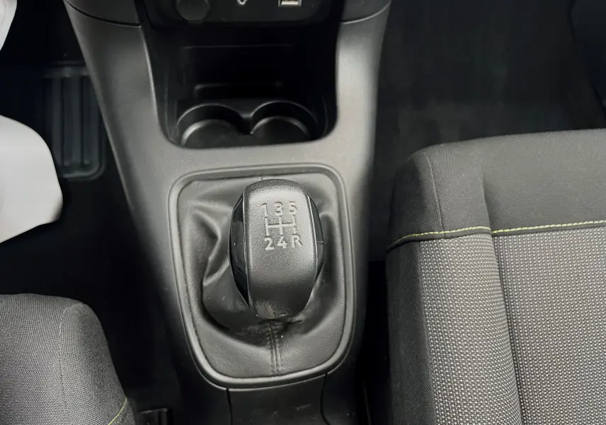 Le levier de vitesses manuel de la Citroën C3 2017 en gros plan, avec siège tissu gris noir visible à droite.