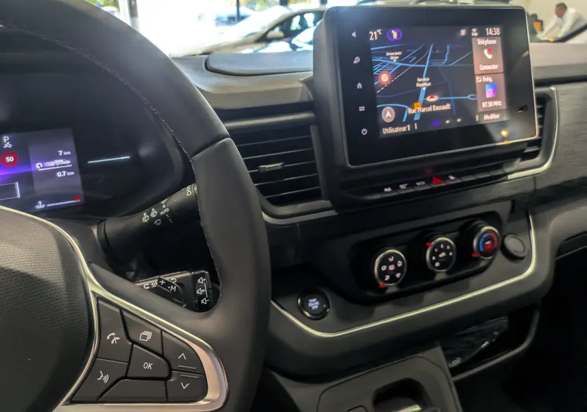 Intérieur du Renault Trafic Combi 2025, vue du tableau de bord avec écran tactile et volant multifonction noir.