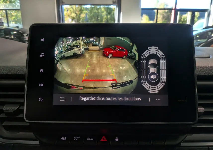 Écran de caméra de recul du Renault Trafic Combi gris comète montrant l’arrière en intérieur avec deux voitures visibles.