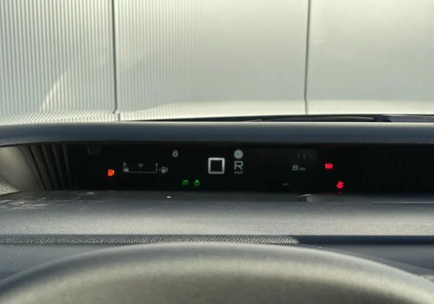 Vue rapprochée du tableau de bord numérique noir du Citroën C3 Aircross Hybrid affichant la vitesse et les alertes.