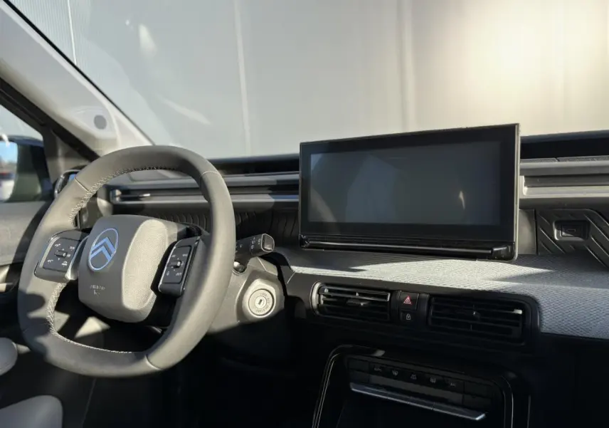 Intérieur avant du Citroën C3 Aircross 2025, tableau de bord gris Sidérite avec écran tactile et volant multifonctions noir.