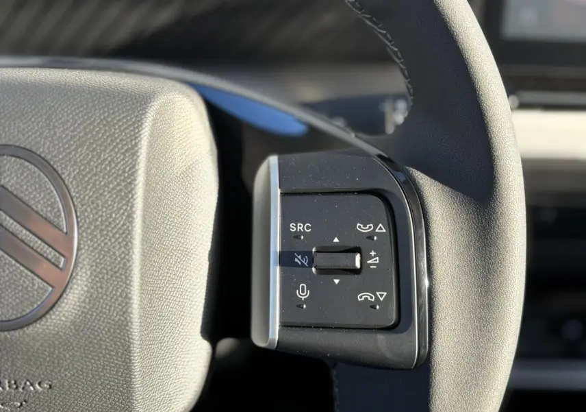 Gros plan sur les commandes multifonctions du volant noir du Citroën C3 Aircross Hybrid 2025.