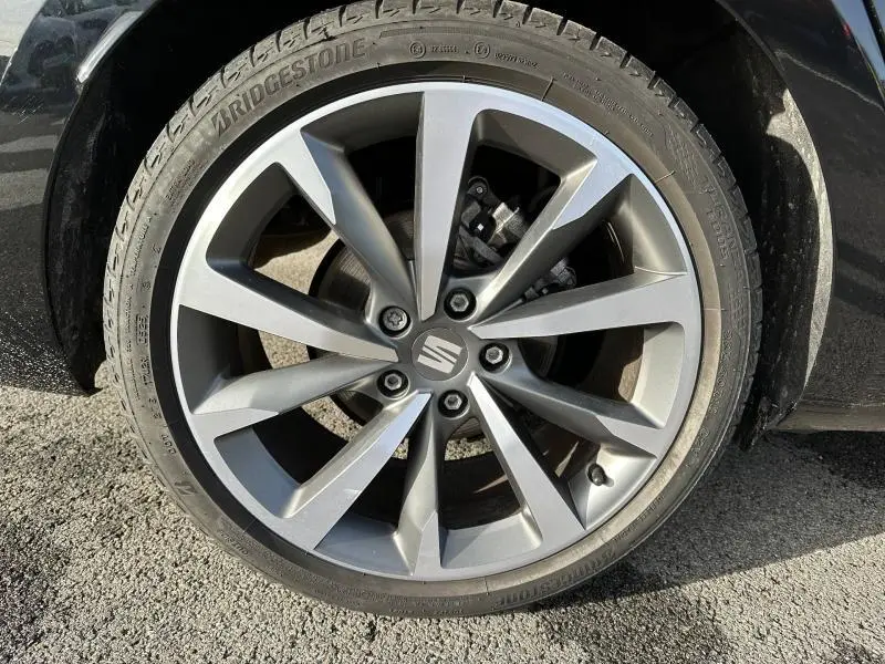 Gros plan sur la jante alliage grise de la SEAT LEON ST 2025 Noir Minuit Métallisée avec pneu Bridgestone visible.