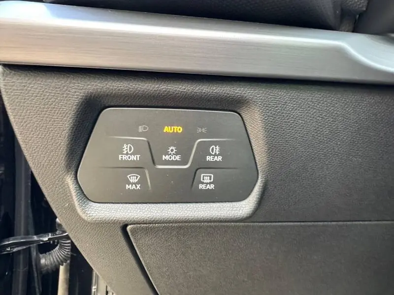 Gros plan sur les commandes d’éclairage et de désembuage sur la planche de bord noire du SEAT LEON ST 2025.