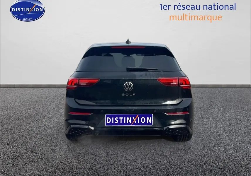 Vue arrière d'une Volkswagen Golf noire 2026 avec feux LED et lunette arrière surteintée sur sol gris.