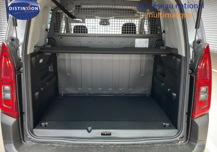 Coffre ouvert d’un Citroën Berlingo gris Artense métal 2026, vue arrière montrant l’espace de chargement et la grille de séparation.