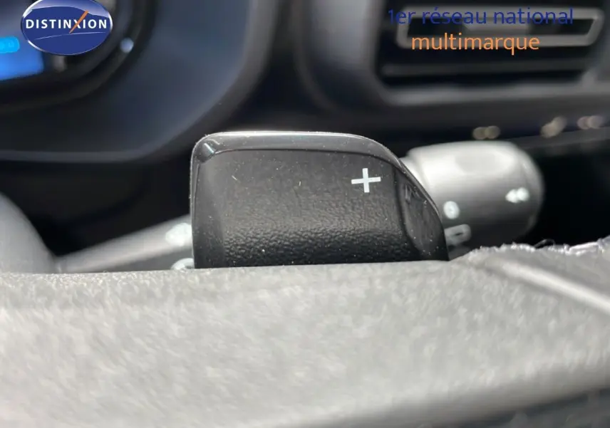 Gros plan sur la palette de changement de vitesse + au volant cuir d'une Citroën Berlingo gris Artense 2026.